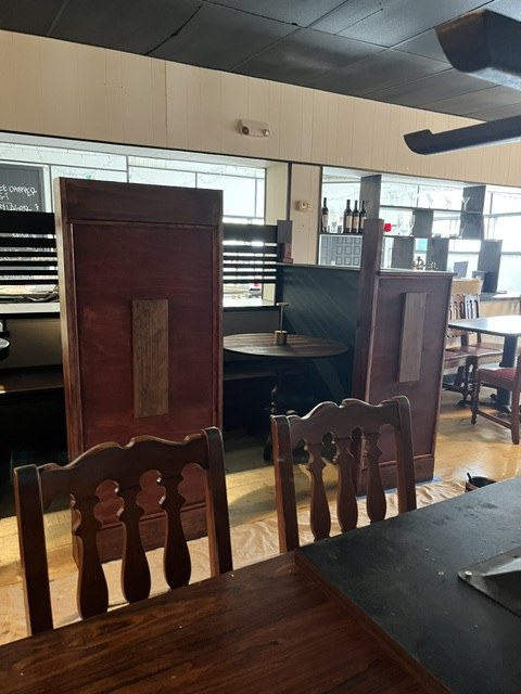 Booth backs in, chairs stacked, floor still covered