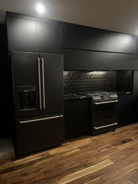 Black fridge and slide-in range in a matte black run