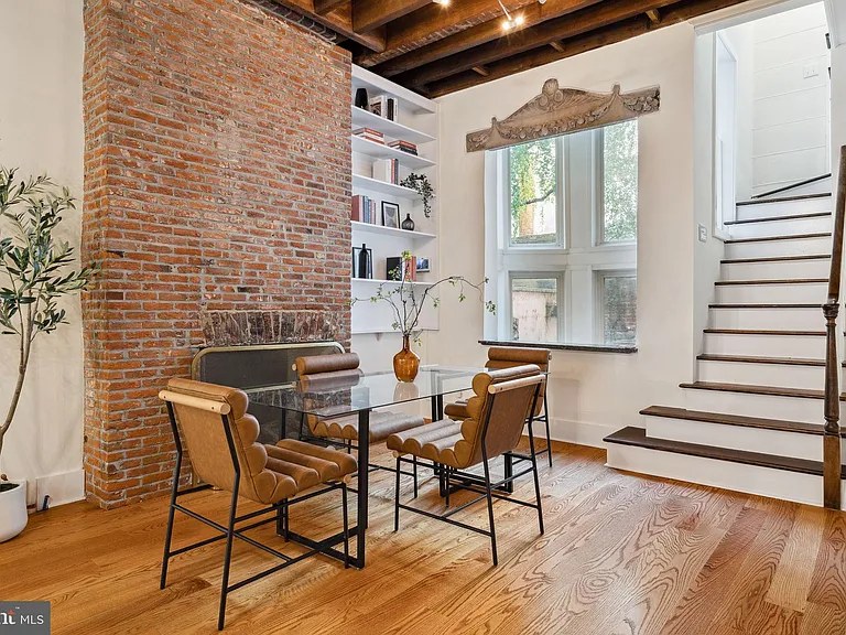 Exposed brick wall beside a black stair