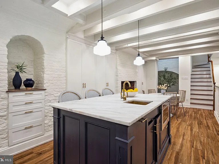 Island kitchen under a white beamed ceiling