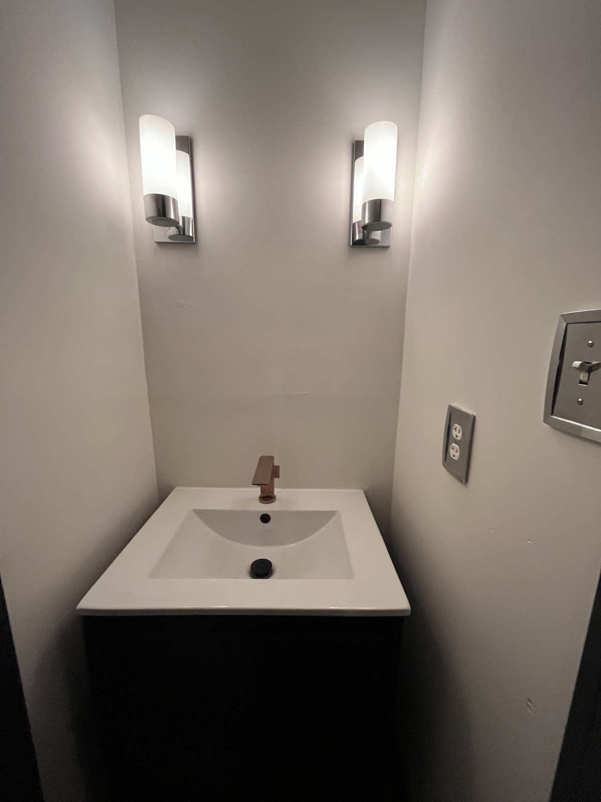 Powder room basin under two sconces