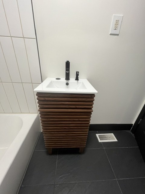 Slatted vanity beside the tub
