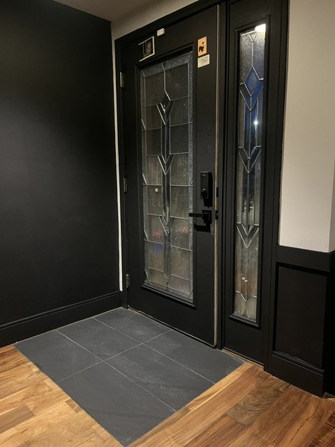 Entry painted black around the leaded glass door
