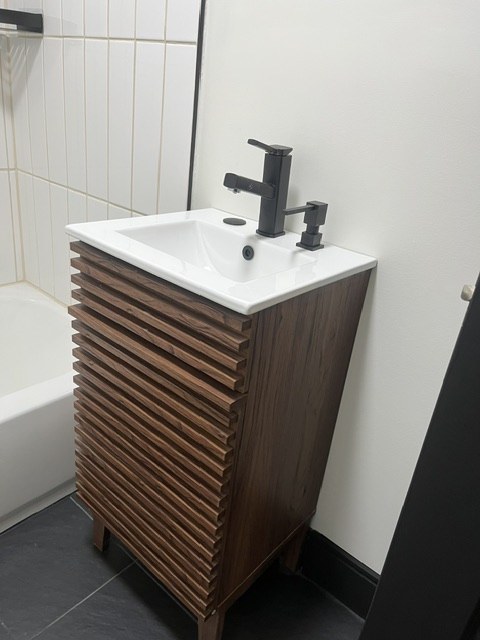 Slatted vanity beside a tub