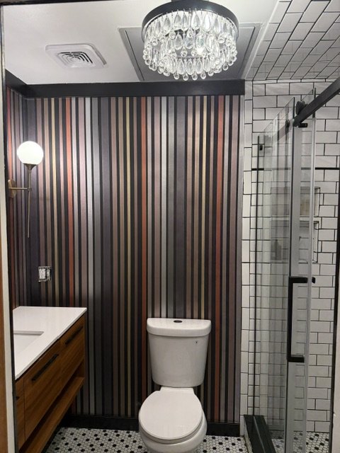 Striped wallpaper beside the shower